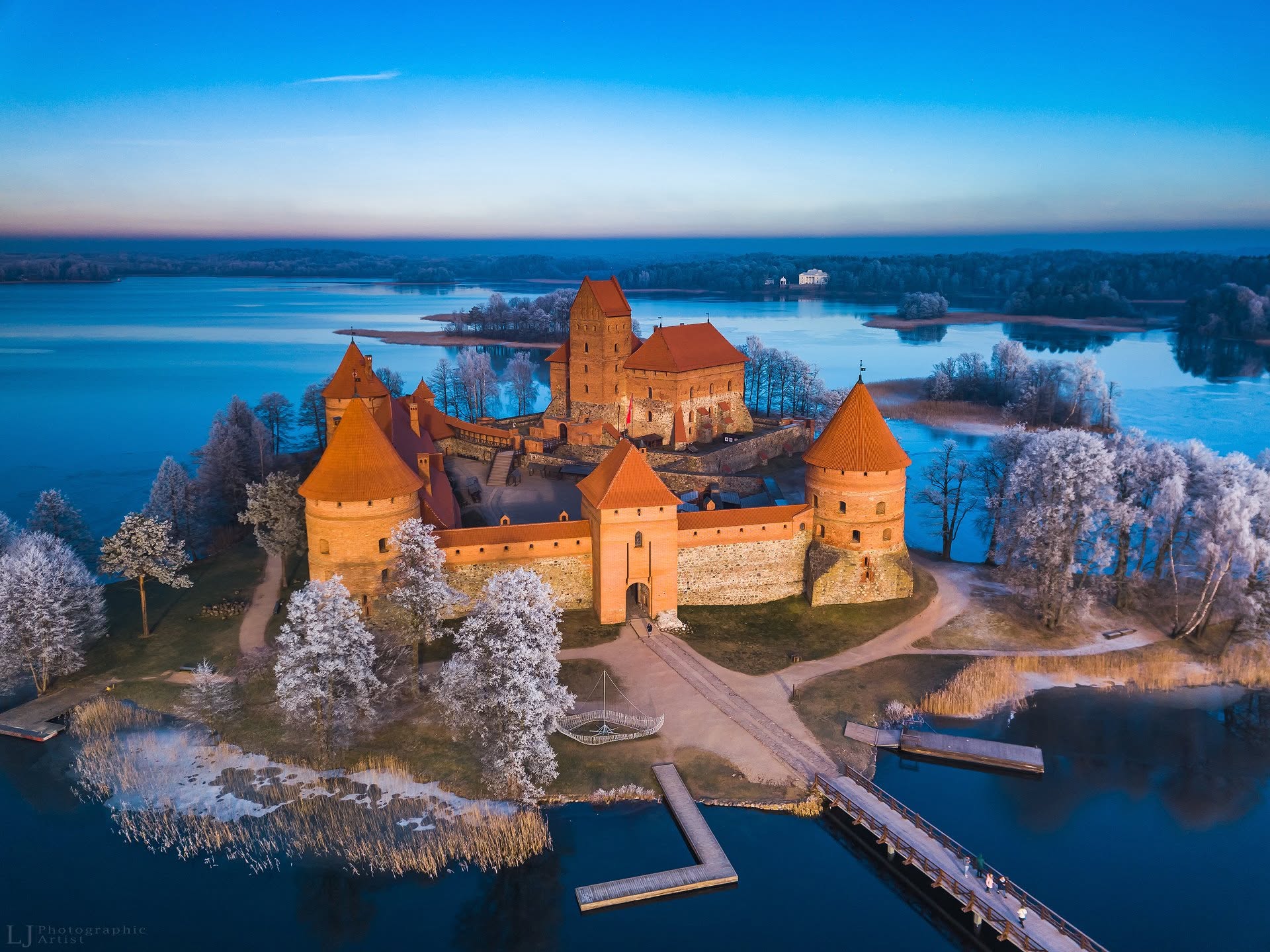 Trakų salos pilis iš drono, apsupta ežero ir šerkšnu padengtų medžių